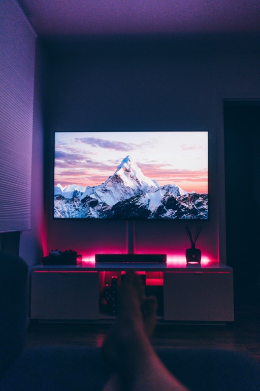 A creative workspace with a screen and colourful lighting